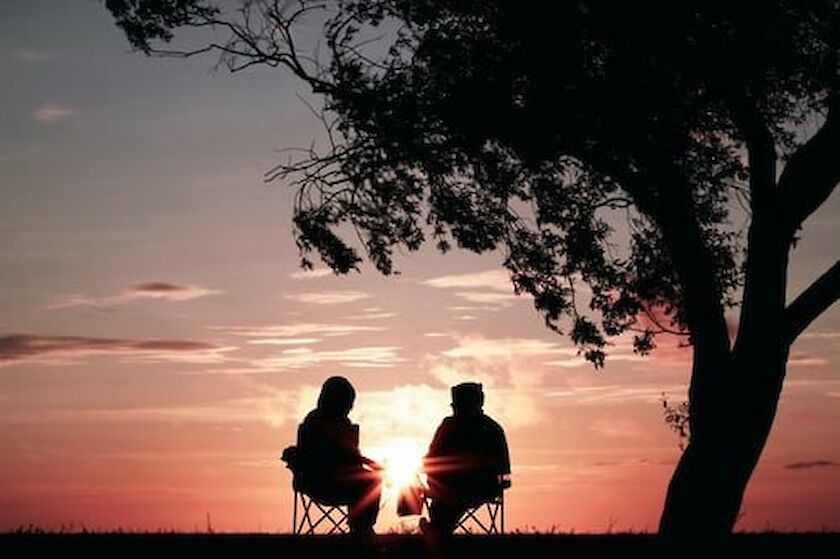Silhouette zweier Menschen vor einem Sonnenuntergang