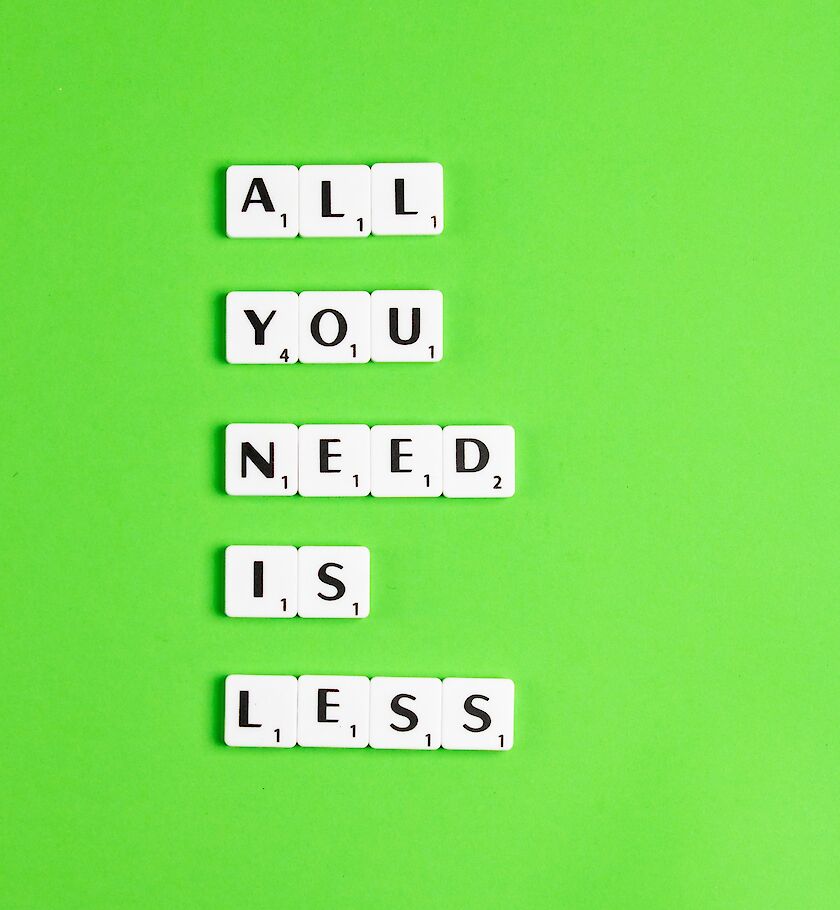 grüner Hintergrund auf dem Scrabble-Buchstaben liegen mit den Worten: All you need is less