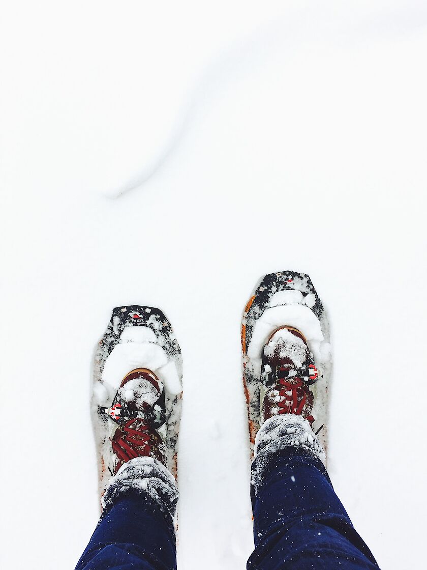 Füße mit Schneeschuhen im Schnee