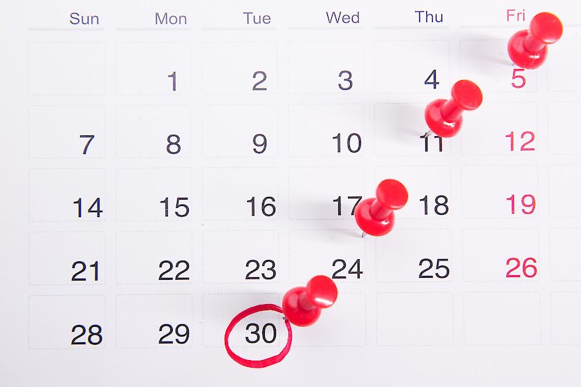 Kalenderblatt mit roten Stecknadeln, der 30. ist rot umkreist